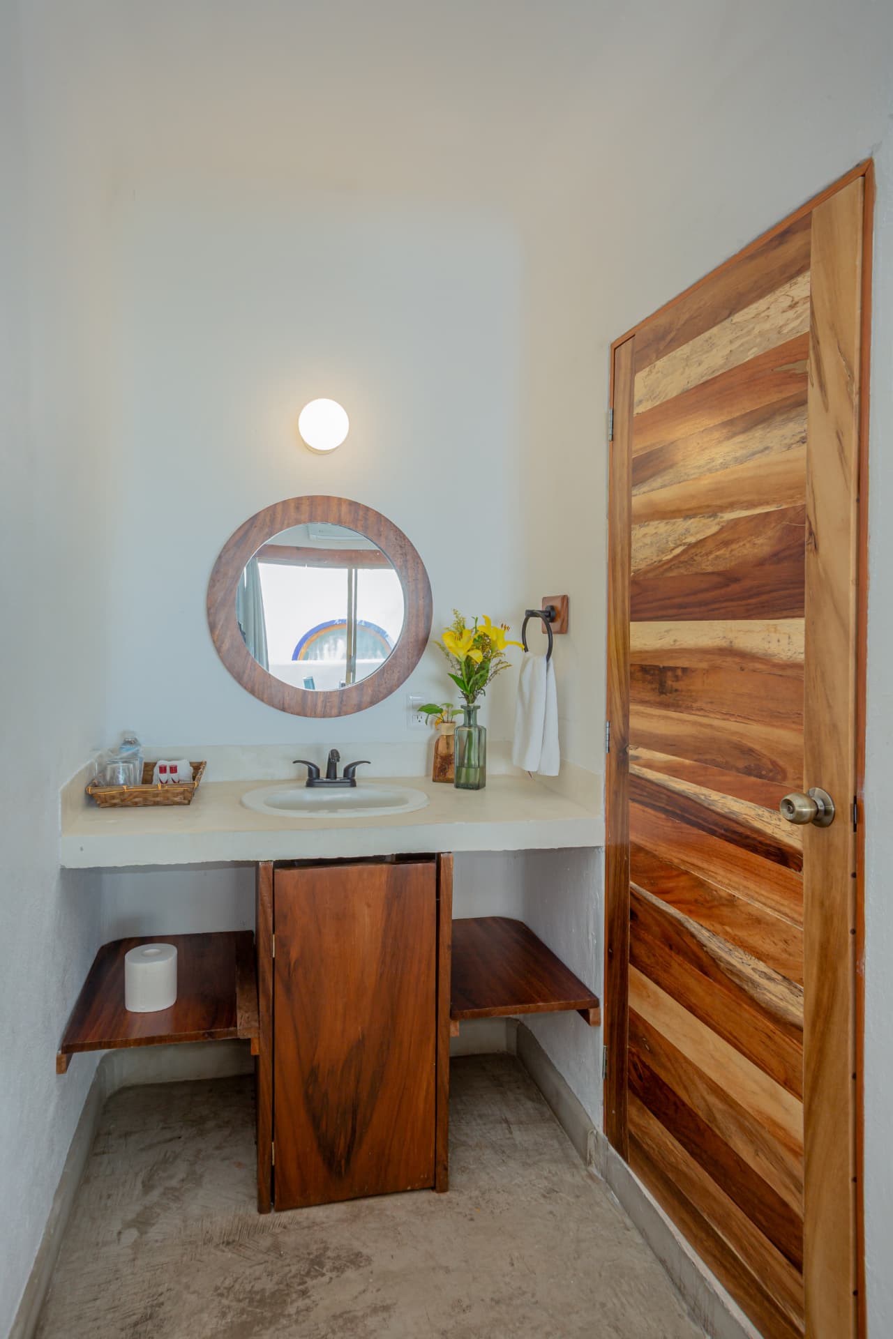 Lavabo con espejo redondo y flores amarillas