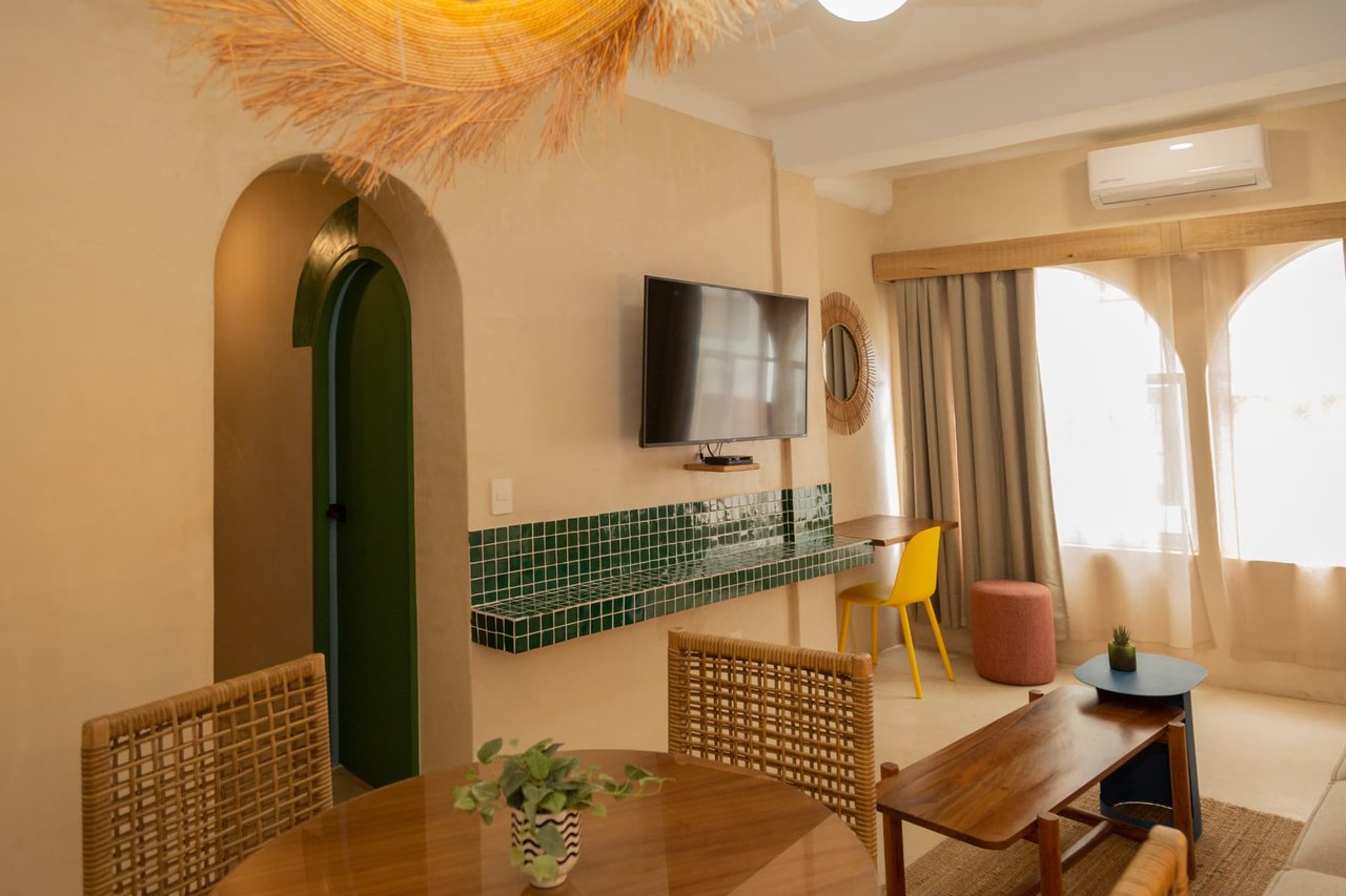 Bright common area of Amaca Residence with dining area, living room and desk