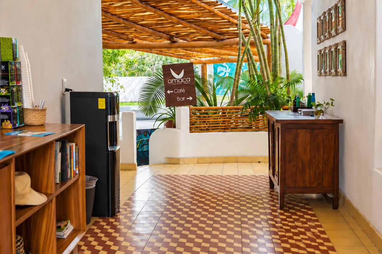 Amaca's reception with a wooden sign pointing to the coffee area and bar
