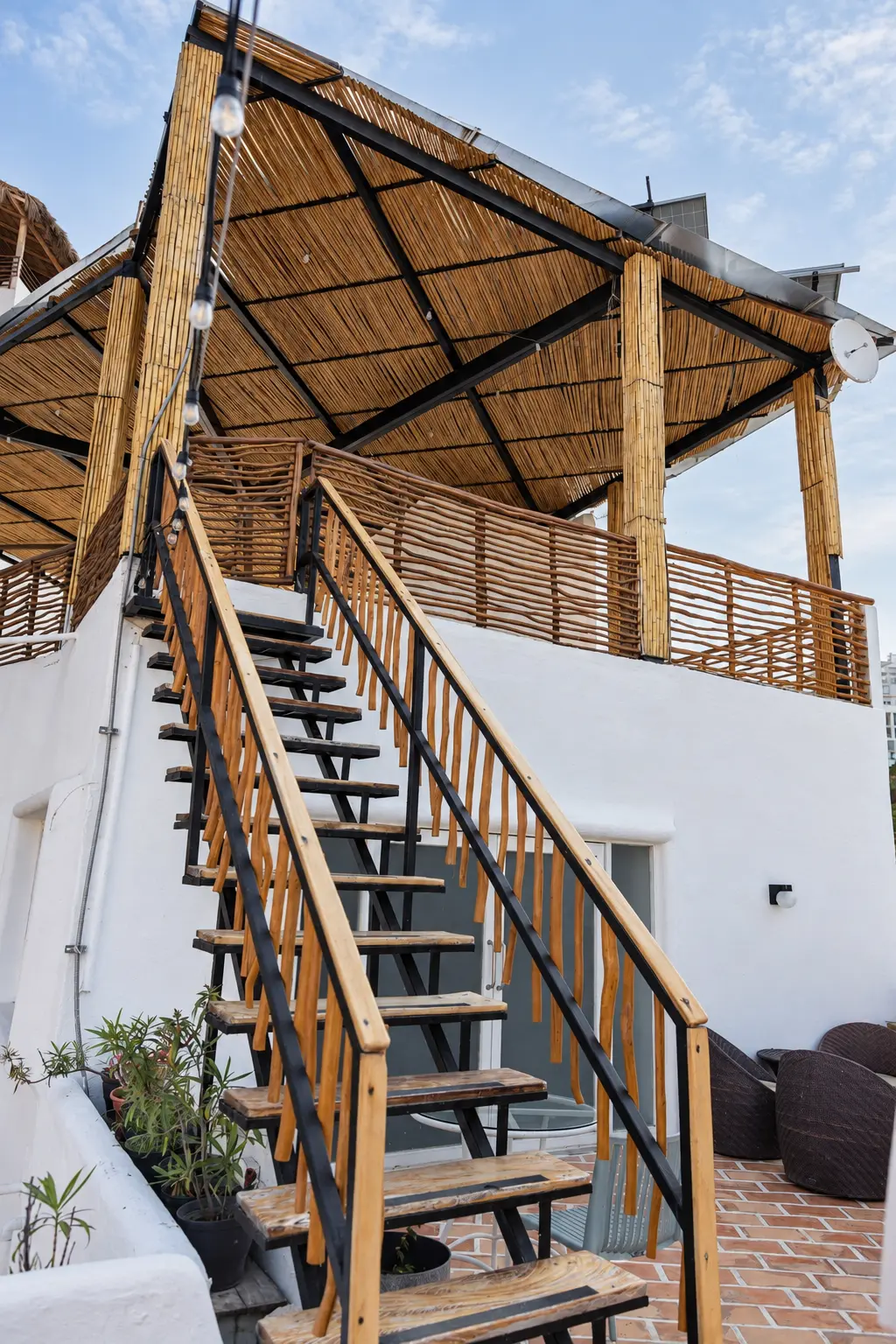 Escaleras de madera y palapa del rooftop de Amaca