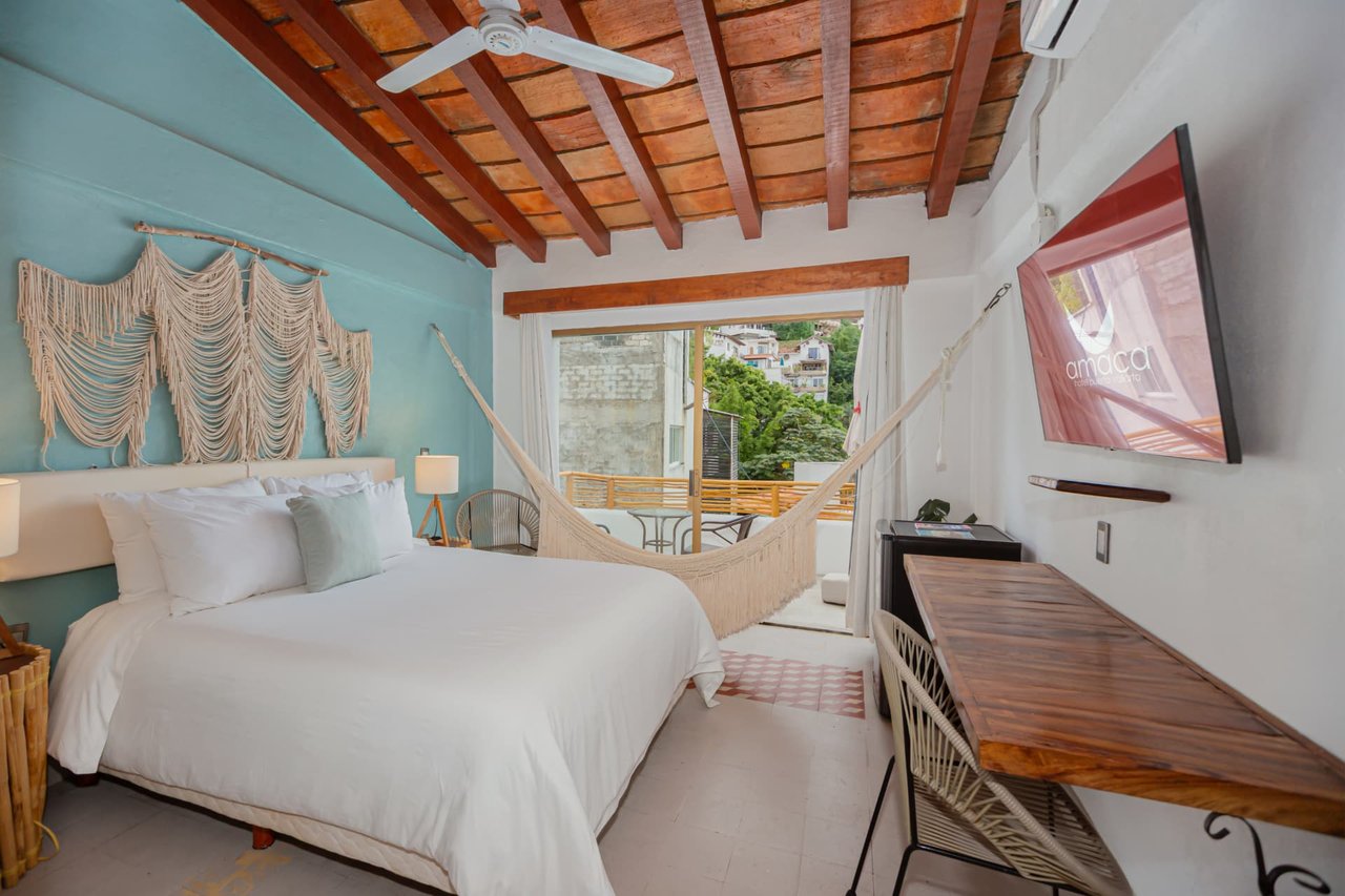 Room 308 with Queen bed, hammock, wood desk and balcony access overlooking the neighborhood