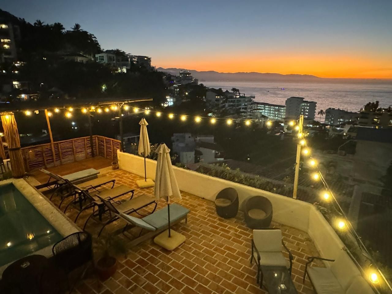 Rooftop de Amaca con la piscina iluminada durante el atardecer