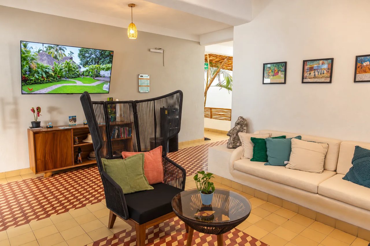 Amaca lobby lounge with sofa, TV and artwork
