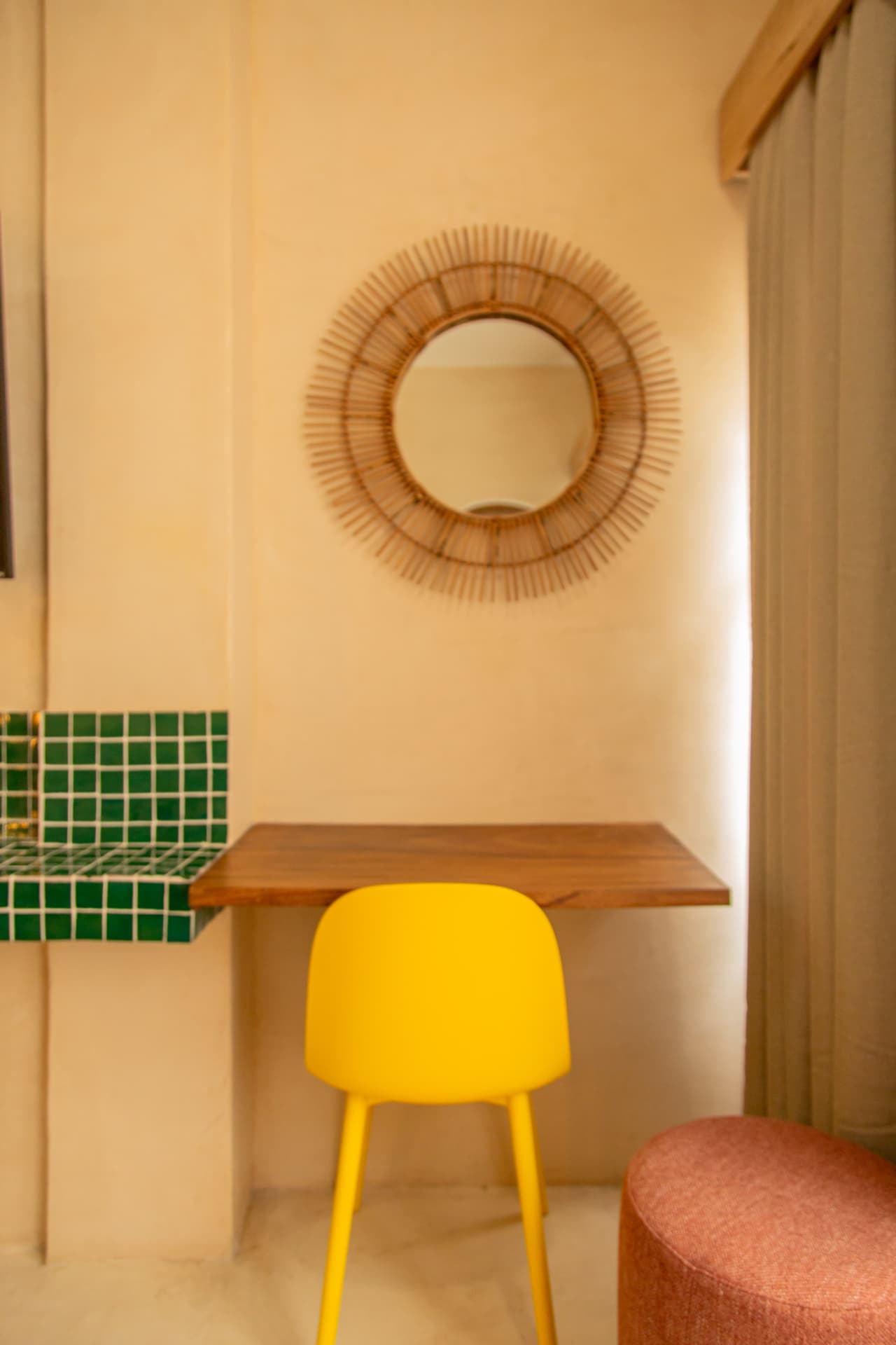 Wooden desk of Amaca Residence with handcrafted mirror, yellow chair and green mosaics