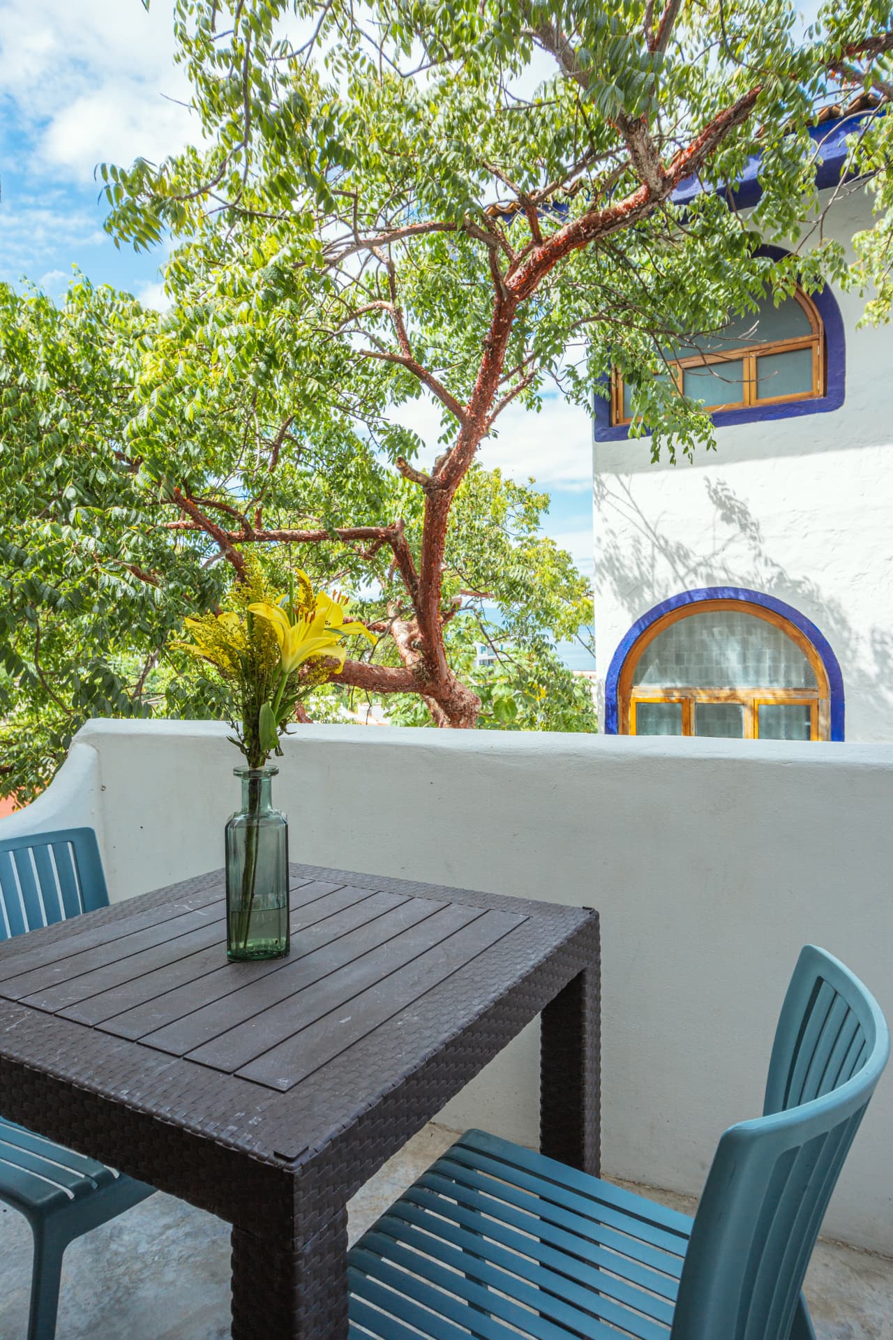 Mesa del balcón con flores y vista al barrio