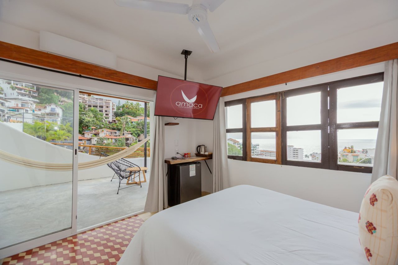Living area of the Deluxe Ocean View with television, mini fridge and terrace access