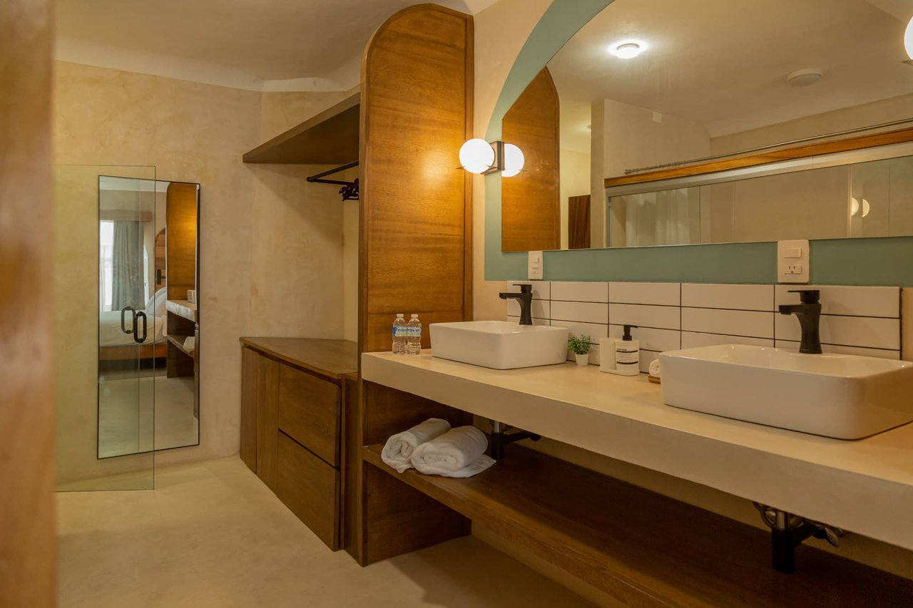Main bathroom of Amaca Residence with two sinks and wooden furniture