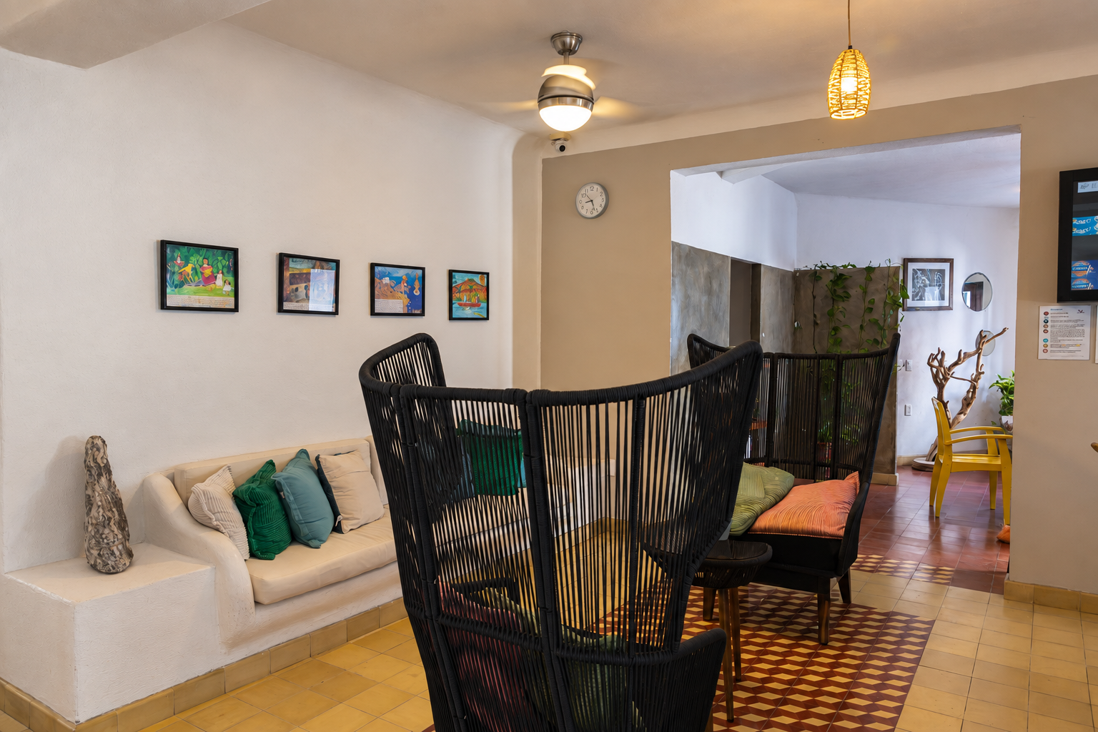 Estancia del recibidor de Amaca con sillones negros y sofá blanco