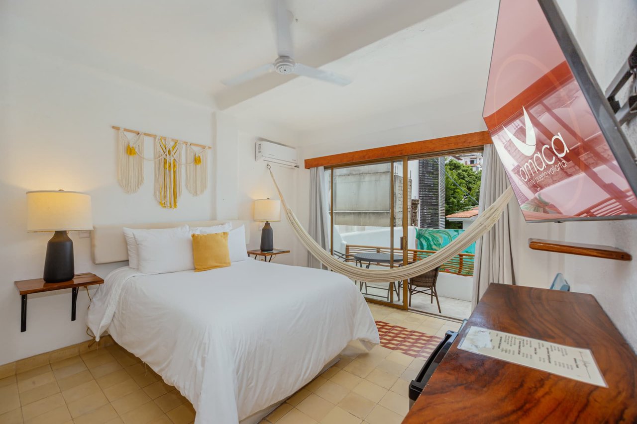 Room 208 with Queen bed, TV and balcony access overlooking the pool