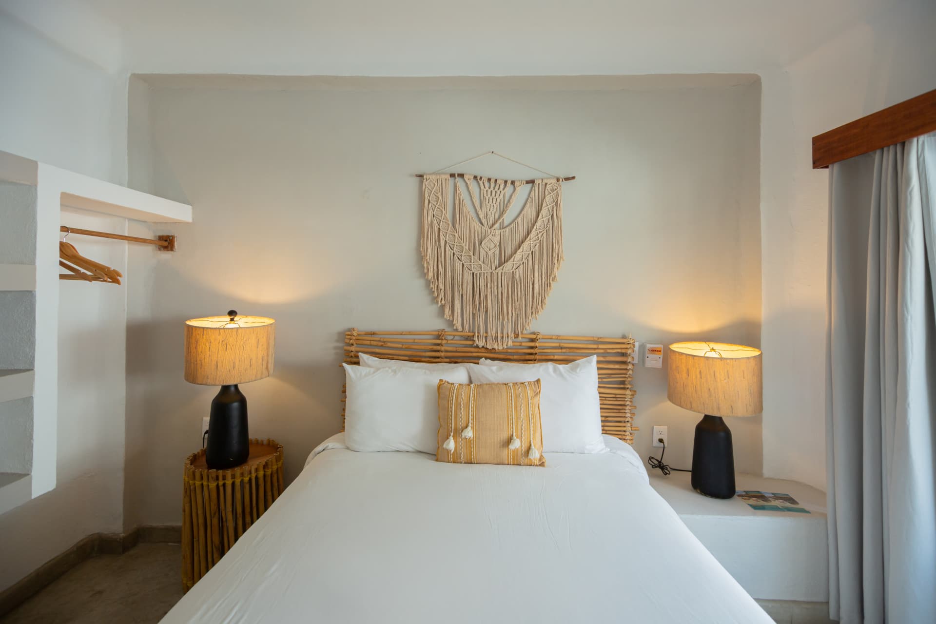 Cama Queen con lámparas y macramé en la habitación 201