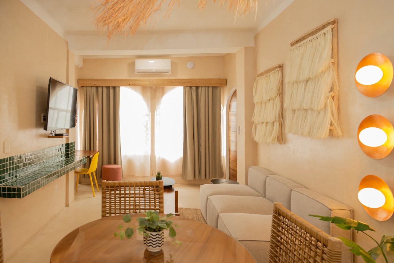 Living room and dining area of Amaca Residence with natural fibers and wooden furniture