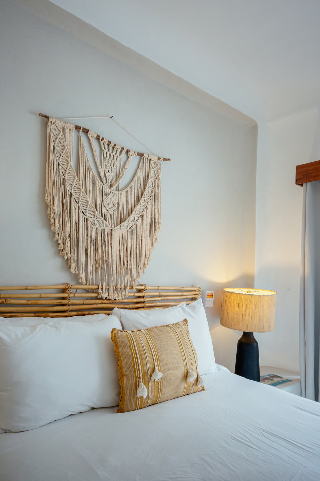 Detalle de macramé y lámpara junto a la cama Queen
