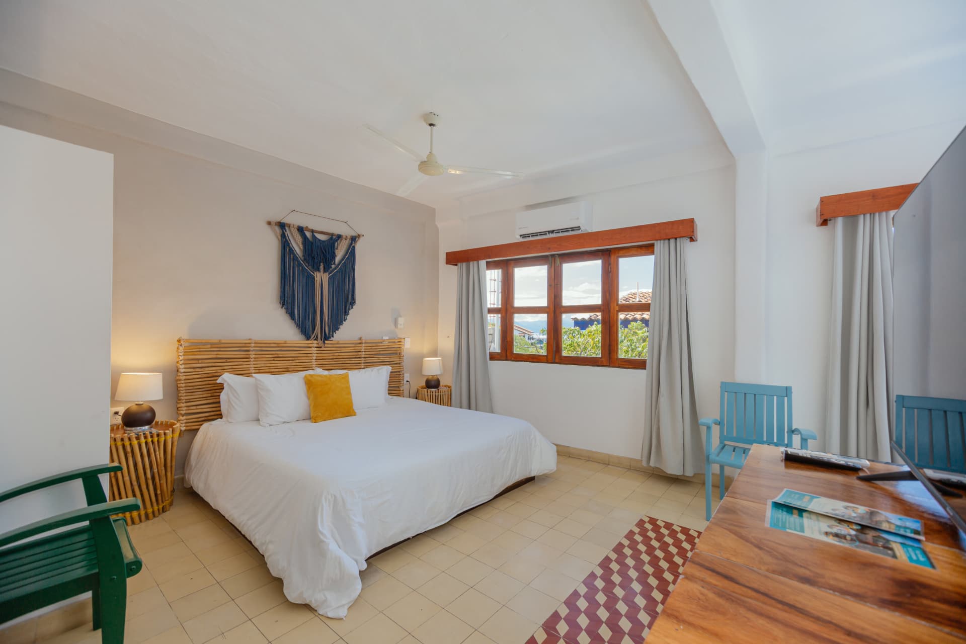 Habitación 202: cama King con cabecera de bambú, macramé azul y escritorio