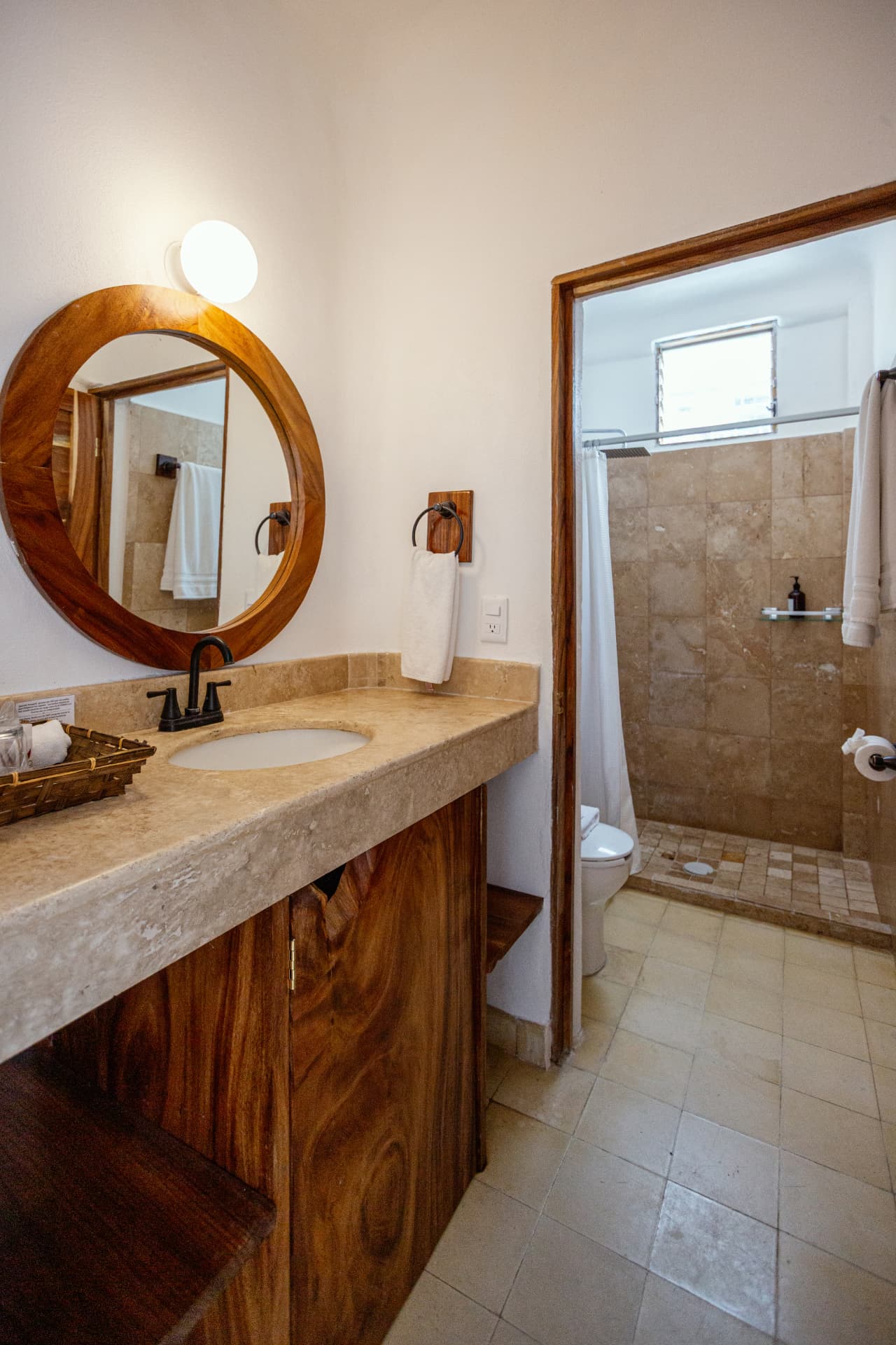 Private bathroom with wooden vanity and round mirror in the Deluxe Ocean View