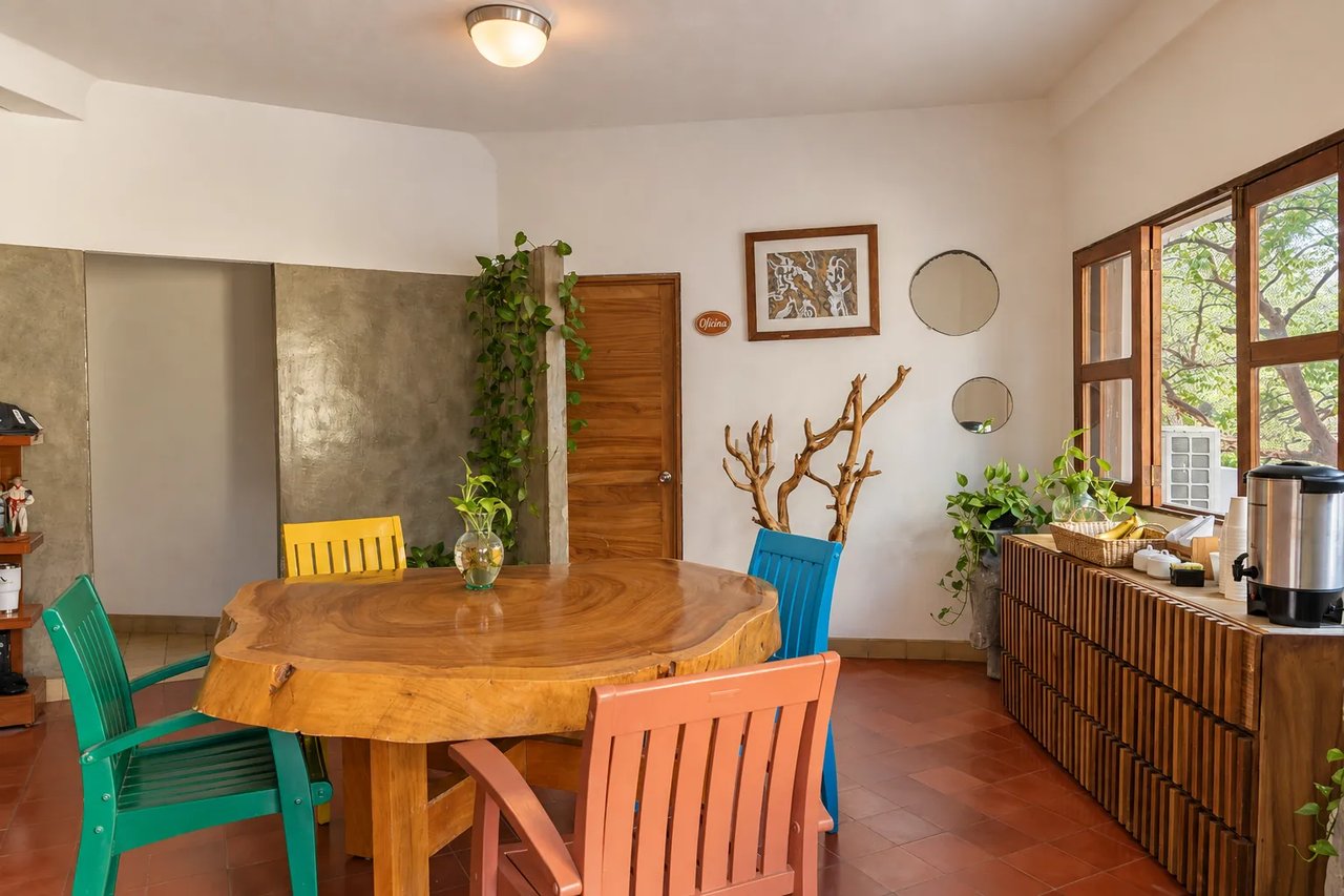Parota wood table with colorful chairs in Amaca's lobby dining area