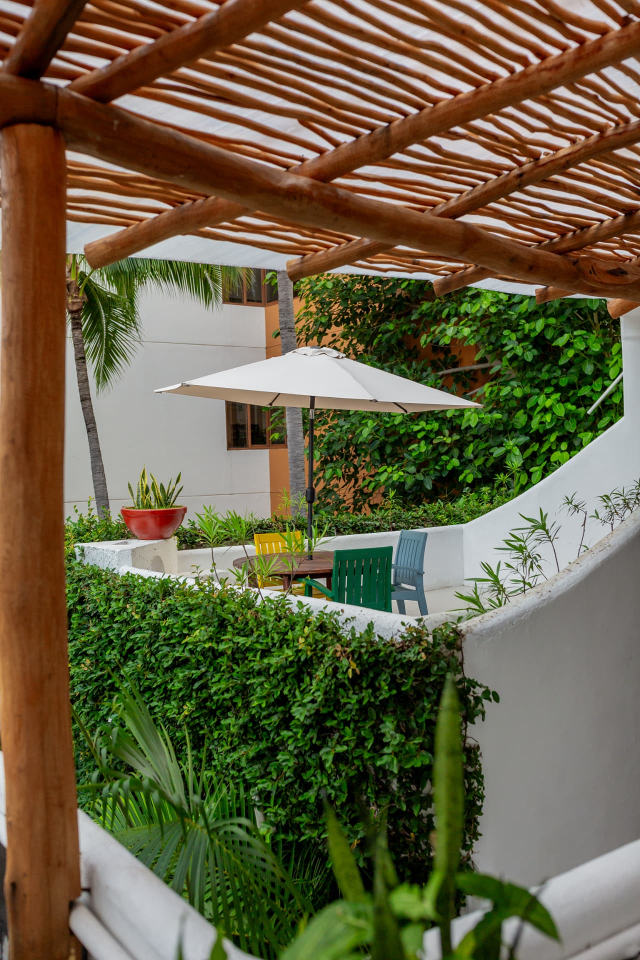 Patio interior de Amaca visto bajo una pérgola de madera