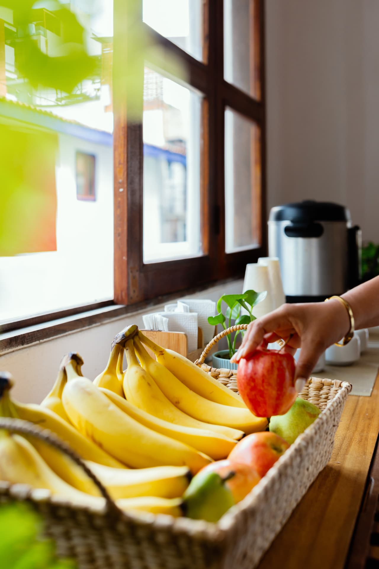 Fruta fresca de cortesía en una cesta junto a la ventana