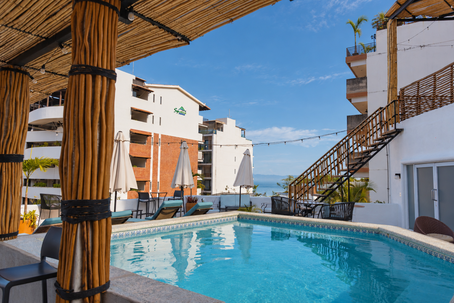 La piscina del rooftop vista desde la pérgola de palapa