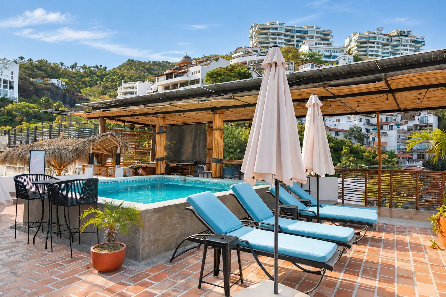 Vista panorámica de la piscina del rooftop con el bar y las colinas de Puerto Vallarta