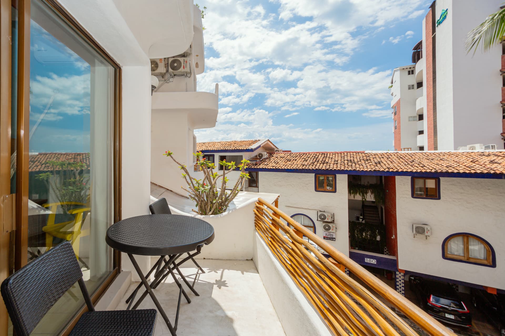 Balcón de la habitación 205 con mesa y vista a los tejados del barrio