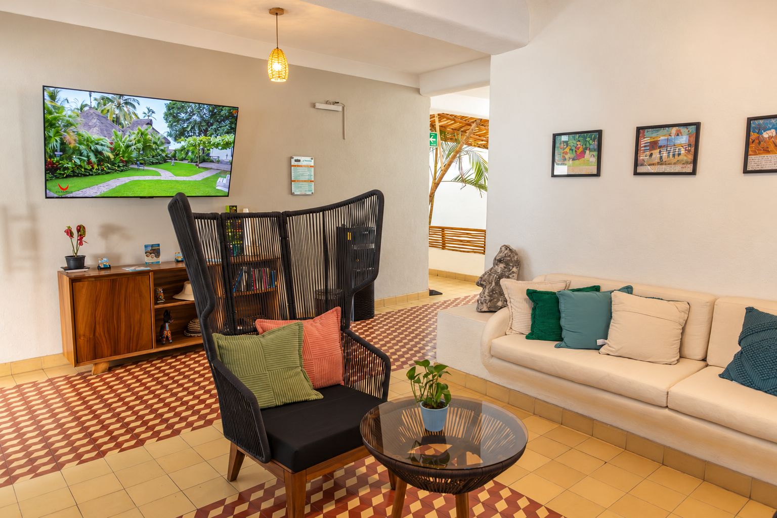 Estancia del lobby de Amaca con sofá, TV y cuadros