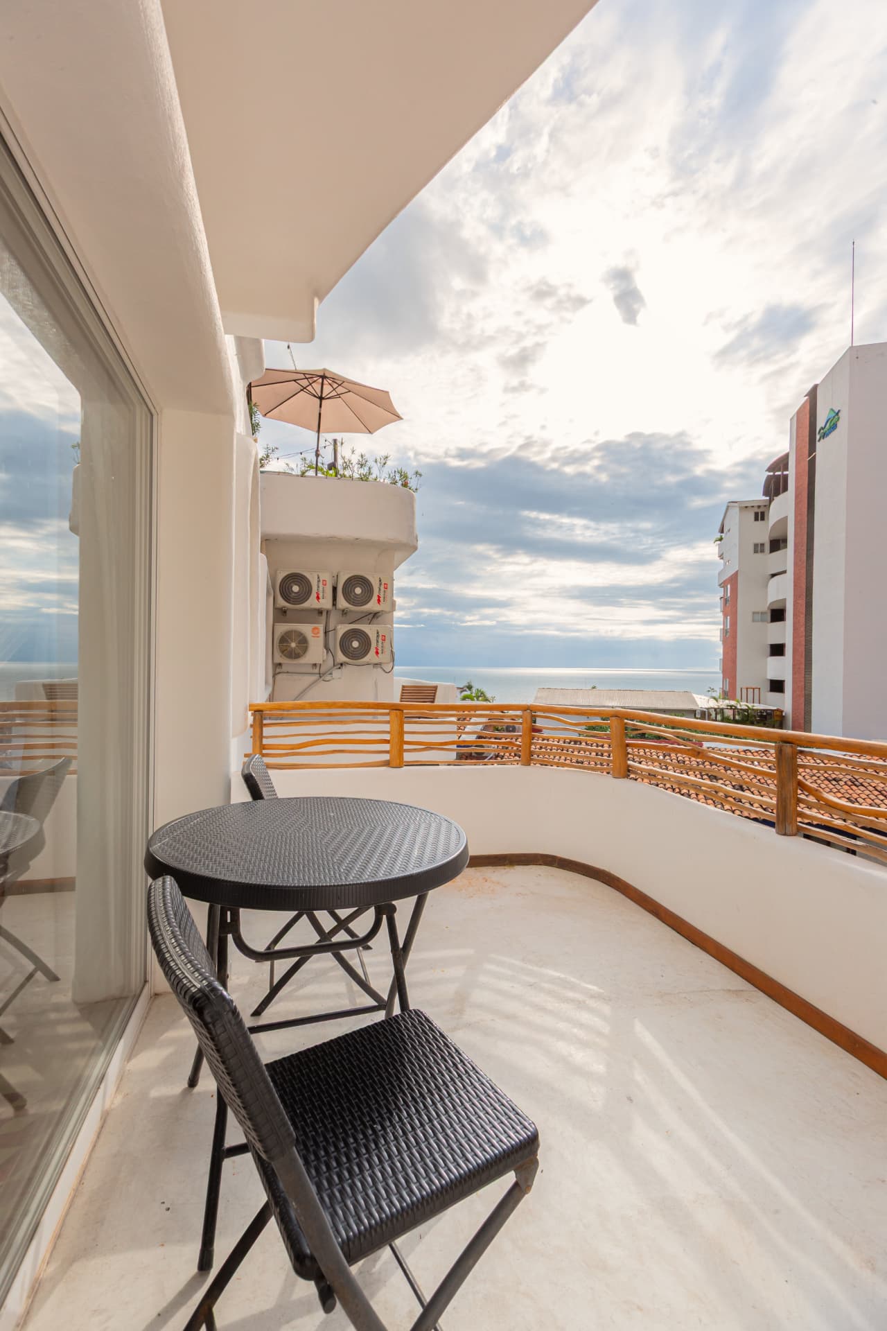 Balcón privado con sombrilla y vista al mar desde la Premium King 305