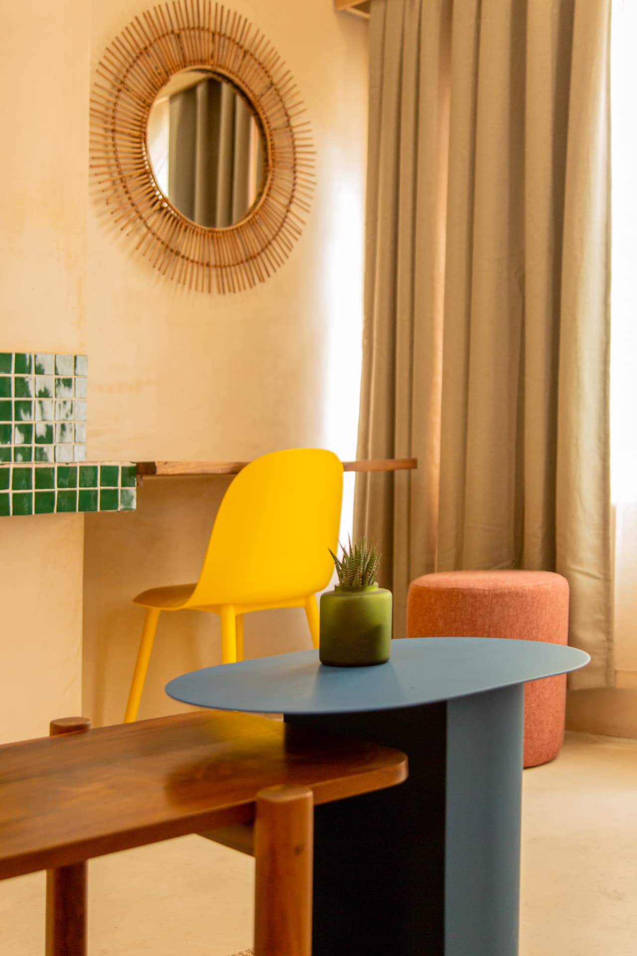 Bright living room of Amaca Residence with blue table, wooden bench and colorful furniture