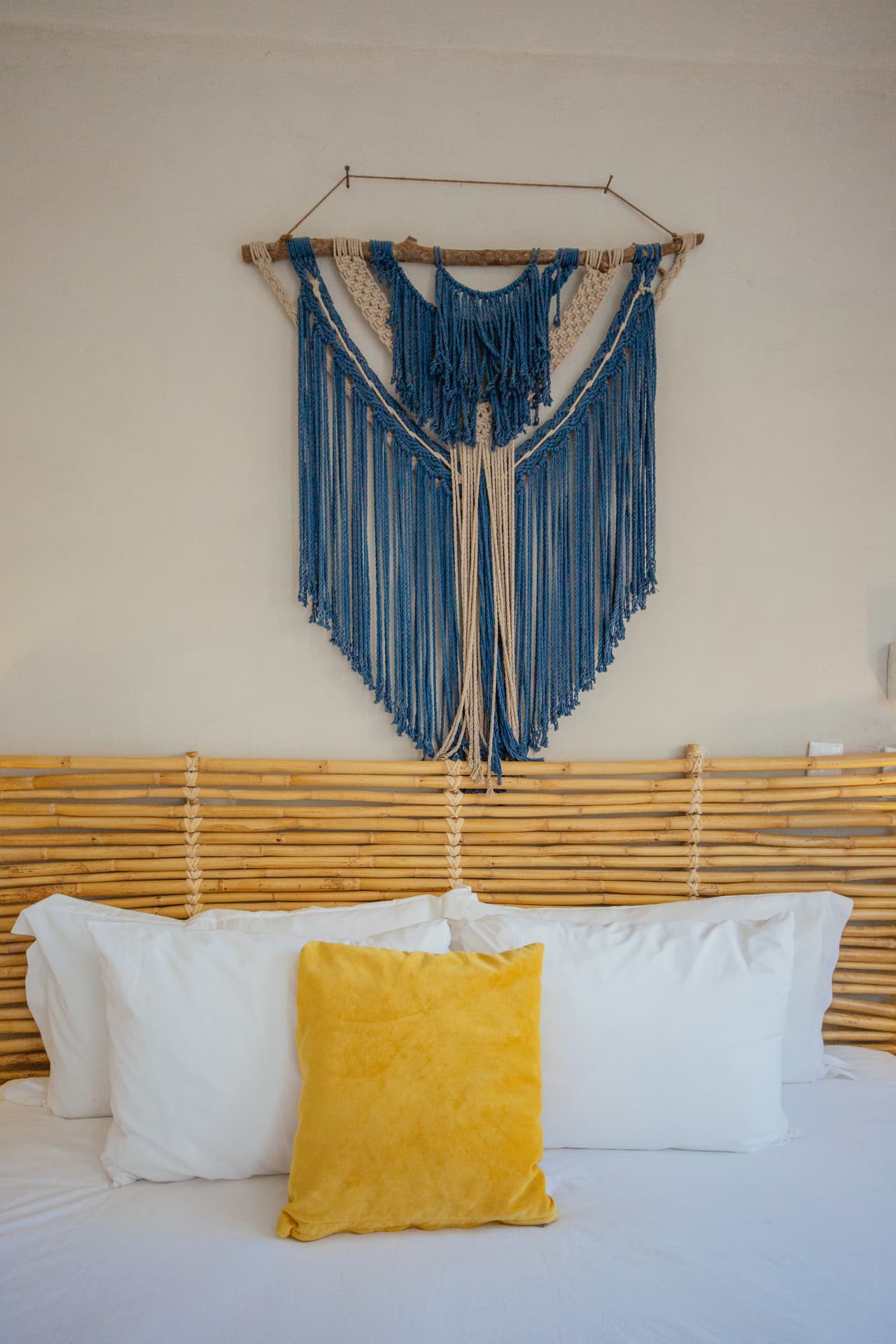 Habitación 202: macramé azul sobre la cabecera de bambú