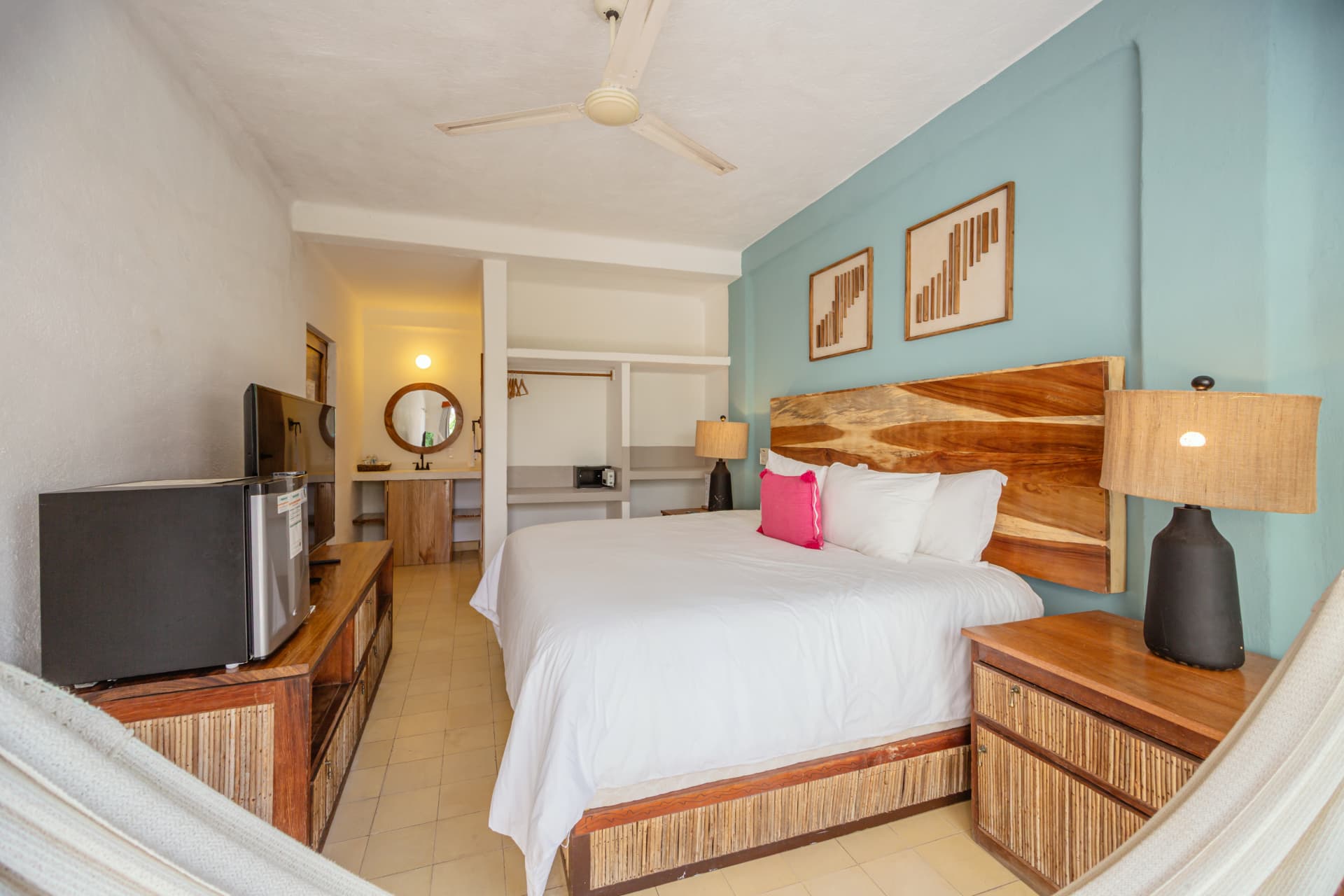 Cama Queen de la habitación 205 con cabecera de madera y pared azul