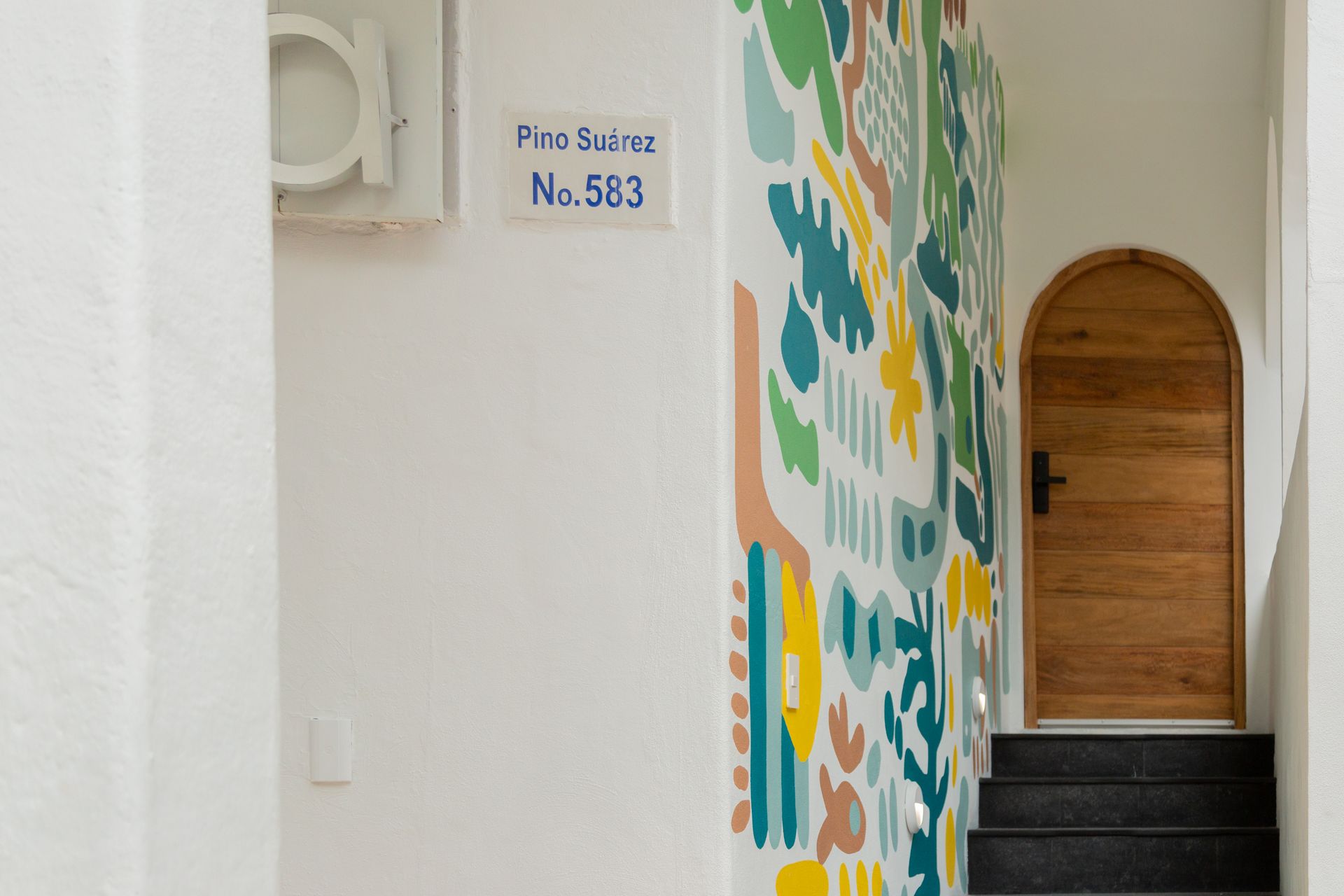 Lobby de Amaca con mosaicos, madera y plantas