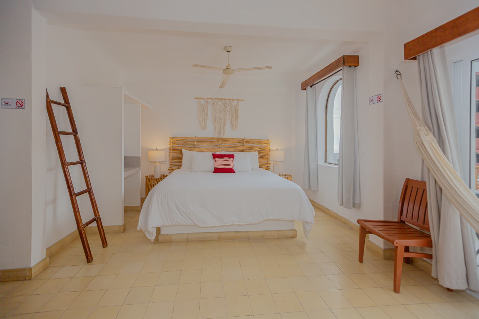 Cama King Size con hamaca y banca de madera en la habitación Premium King 305