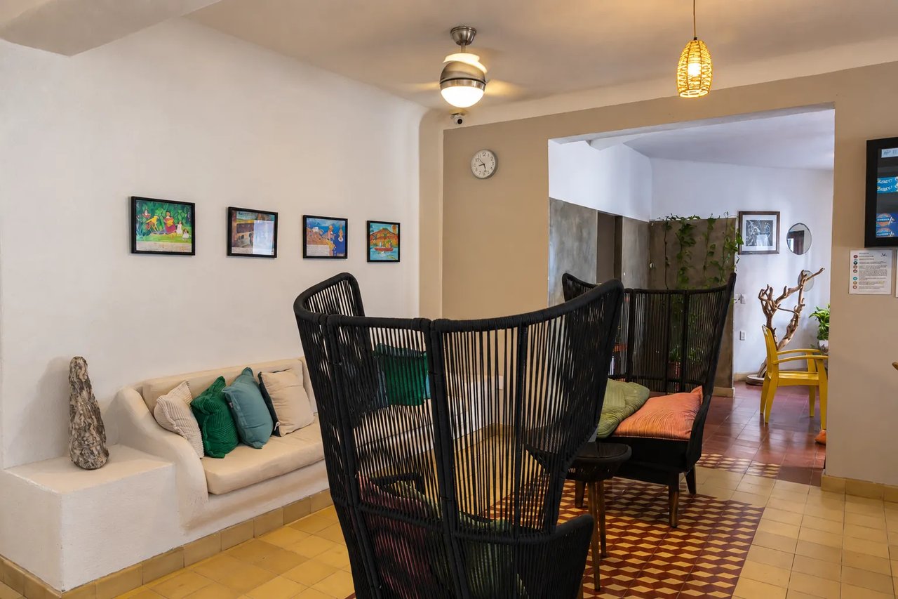 Woven armchairs and a white sofa in Amaca's lobby lounge