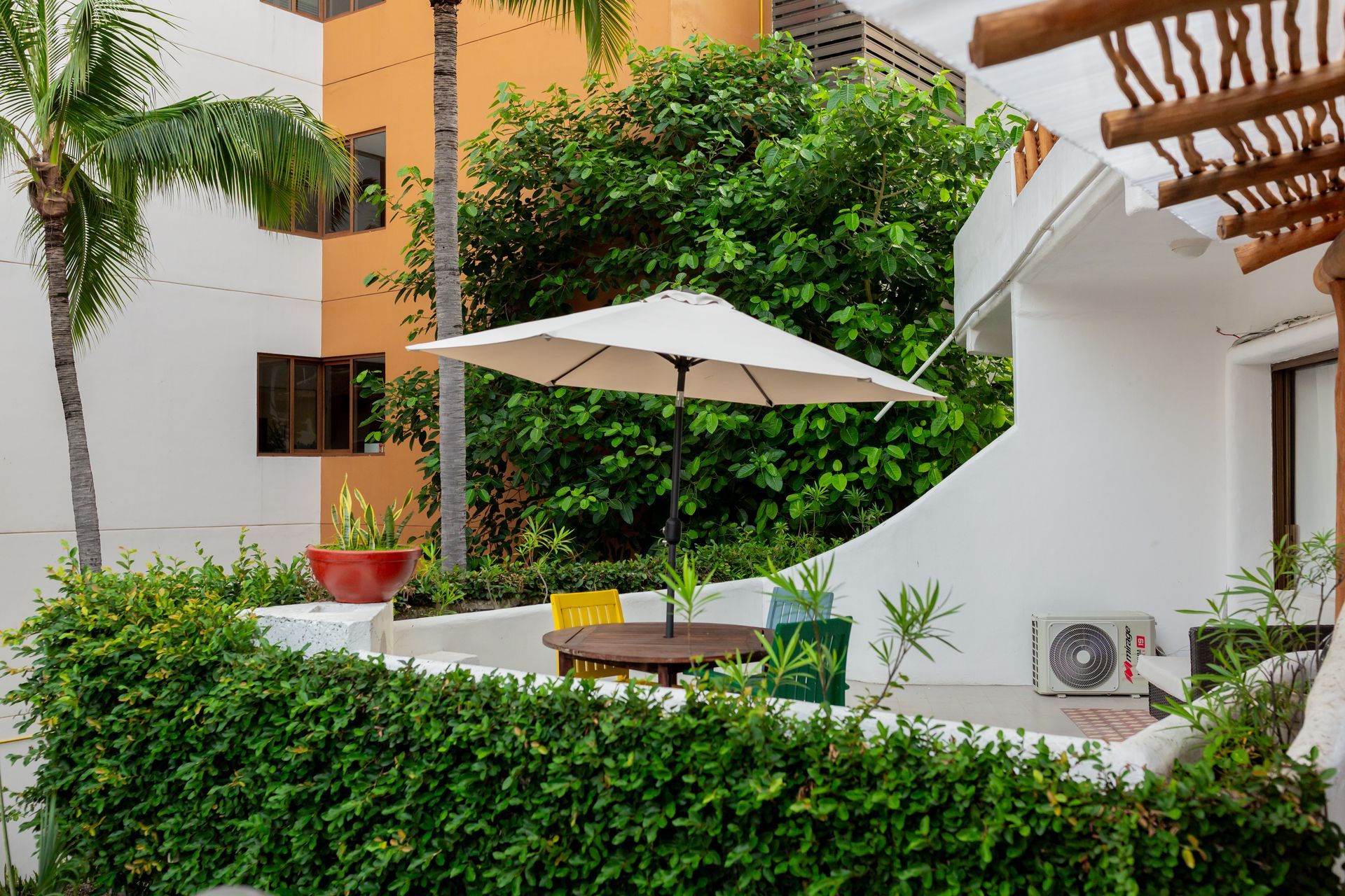 Vista desde la terraza del piso 1 de Amaca, con vegetación y arquitectura blanca