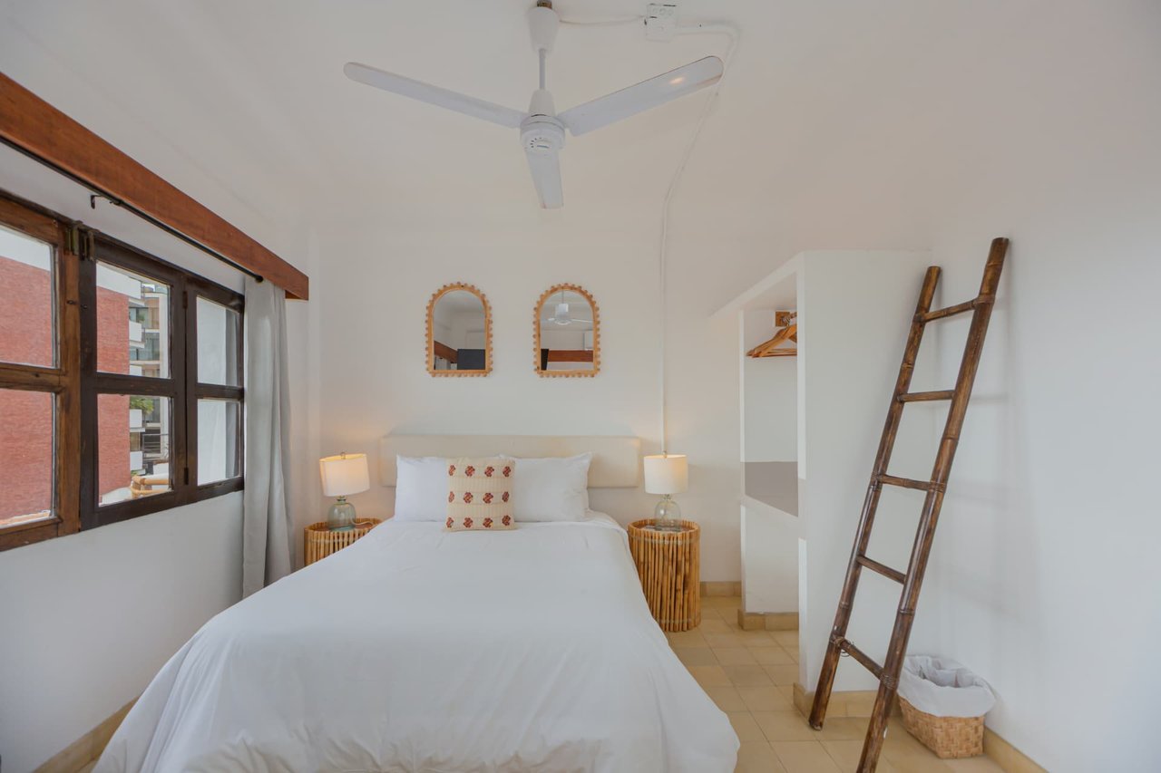 Deluxe Ocean View room with double bed, wooden stairway and handcrafted mirrors
