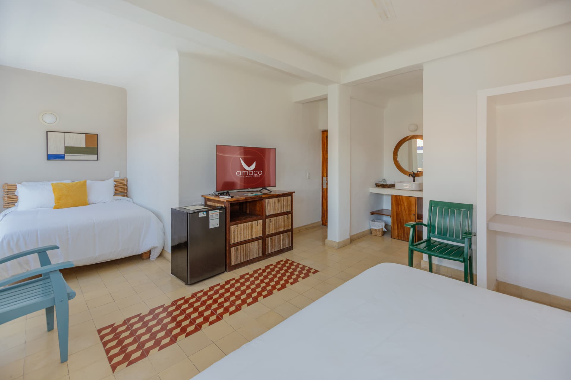 Room 202 with the two beds, television, minibar and vanity with round mirror