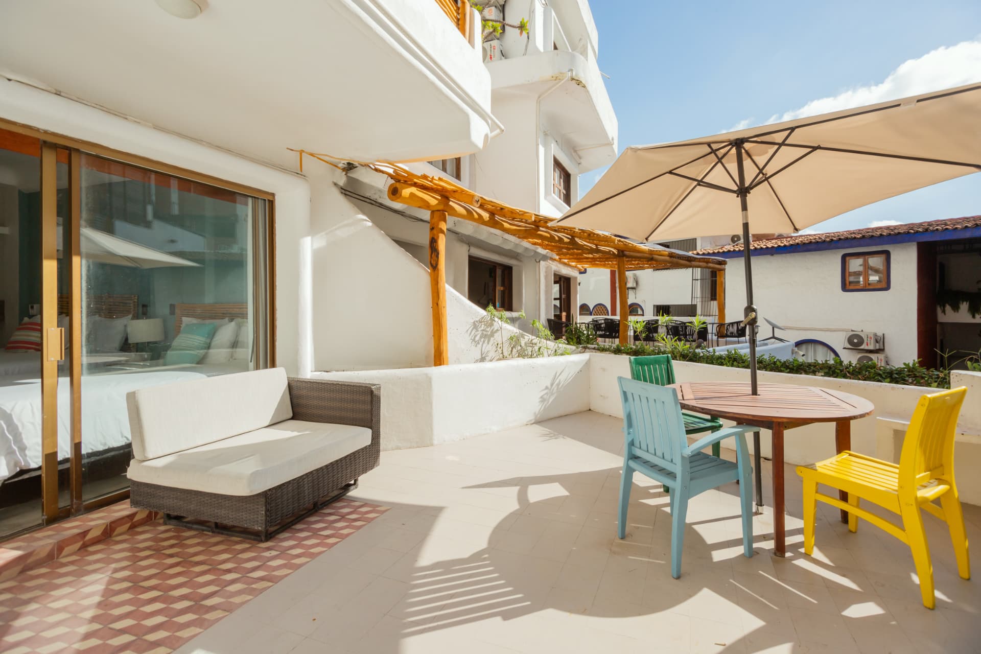 Habitación 105: terraza con sofá de fibra y sombrilla