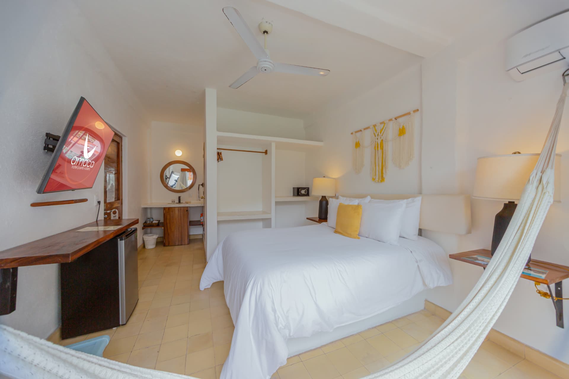 Vista amplia de la habitación 208 con cama Queen, hamaca, ropero y cocineta de apoyo