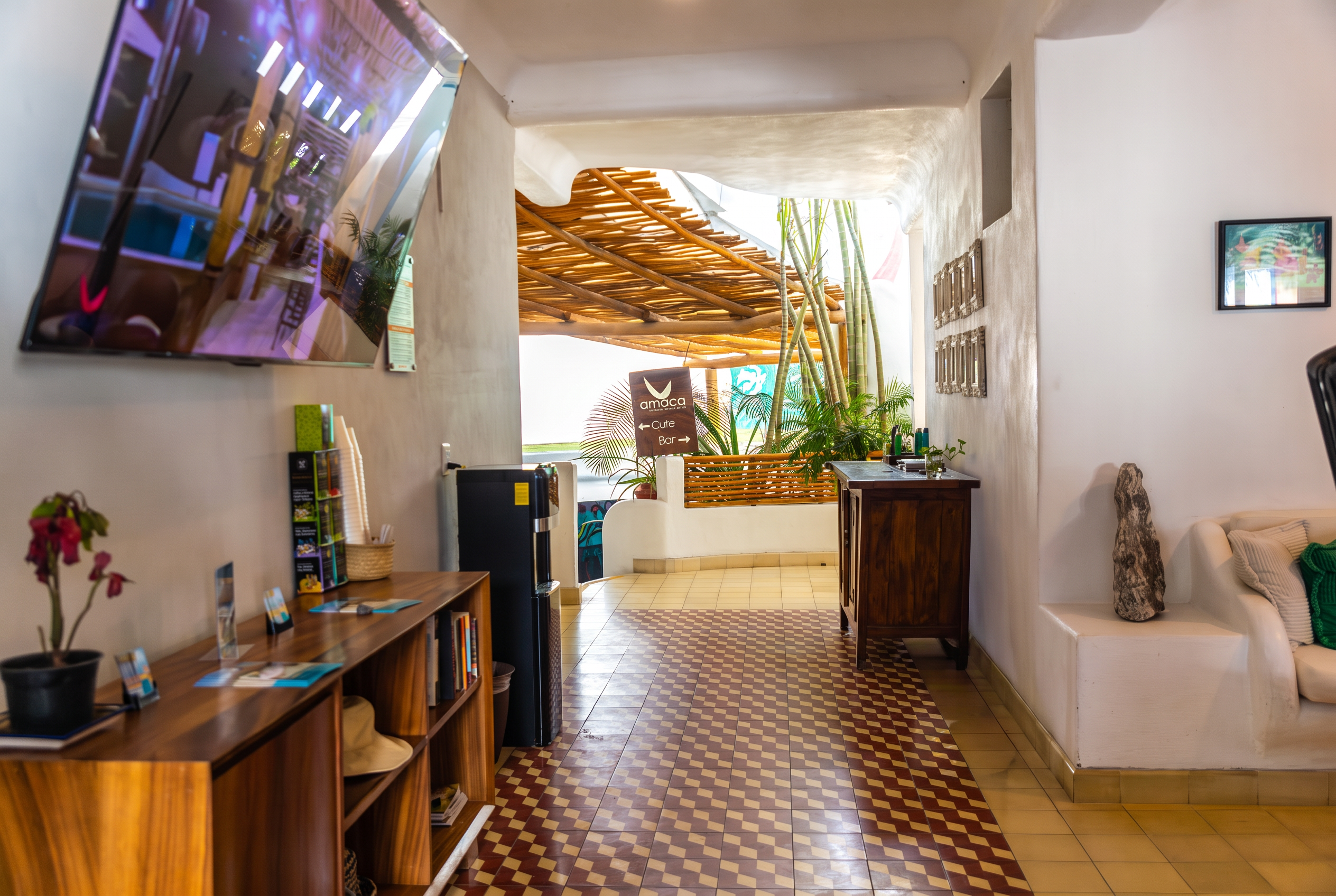 Interior del lobby de Amaca con pisos de mosaico, madera y luz natural
